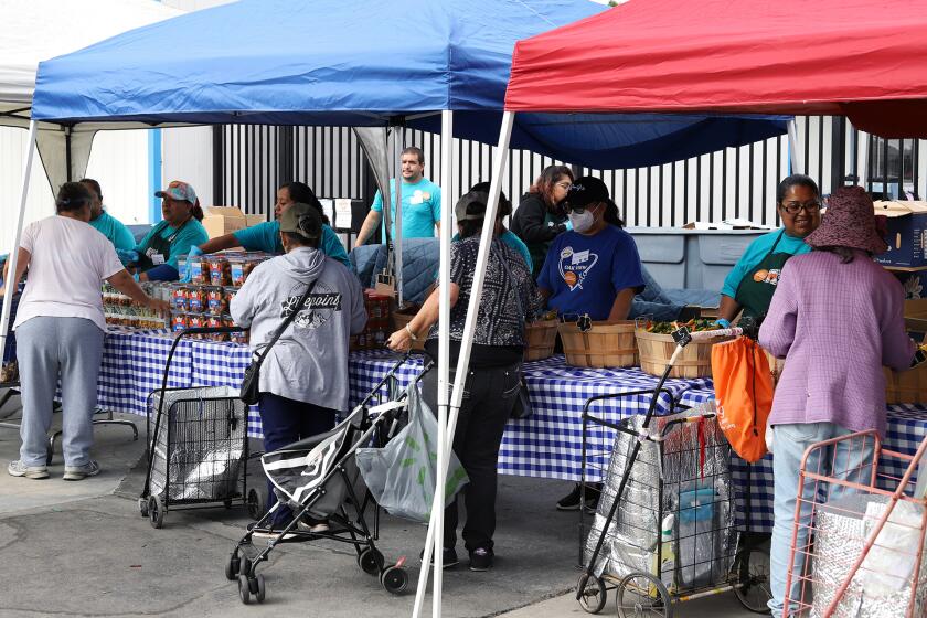 People from the Oak View Community pick through a variety of fresh produce during the Second Harvest Food Bank's Mobile School Pantry Program celebrating a decade of serving Orange County families at Oak View Elementary School in Huntington Beach on Wednesday, September 11, 2024. (Photo by James Carbone)