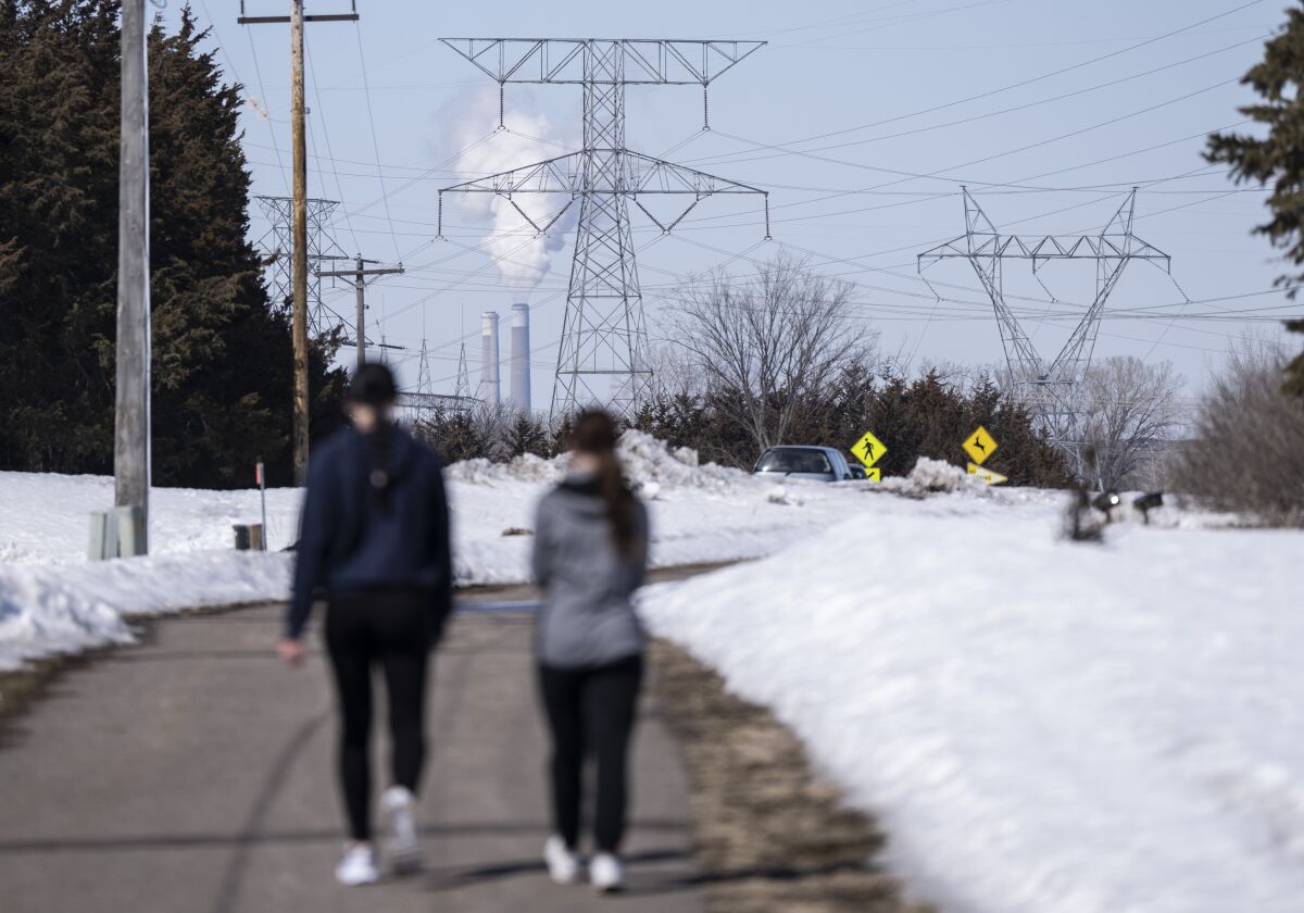 People walk on a trail at the Montissippi County Park near the Xcel Energy Monticello Generating Plant, a nuclear power plant, in Monticello, Minn., on Friday, March 24, 2023. (Renee Jones Schneider/Star Tribune via AP)