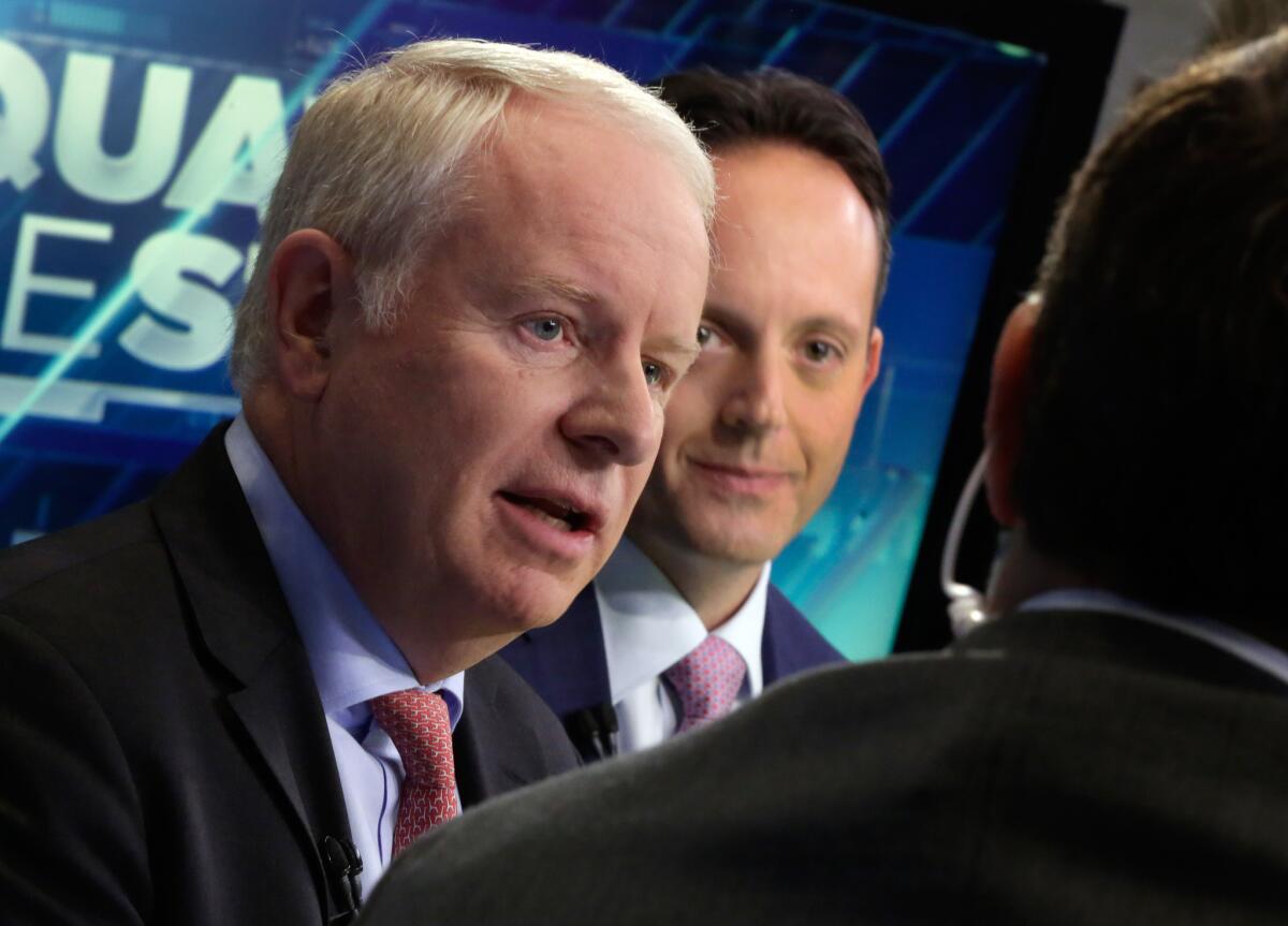 Allergan CEO David Pyott, left, and Actavis CEO Brenton Saunders on the floor of the New York Stock Exchange on Monday.