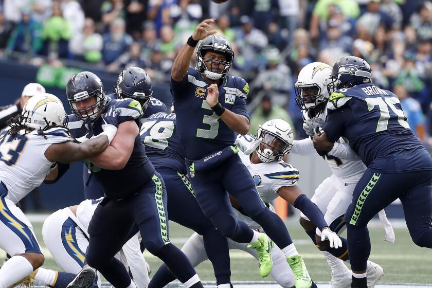 Seattle Seahawks quarterbck Russell Wilson feels pressure from the Chargers' defensive line in the second quarter Sunday at Century Link Field in Seattle.