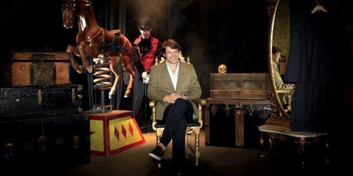 Film producer Jason Blum ("Paranormal Activity"), sits, while Thom Spence, head of production, stands in the shadows in the "Blumhouse of Horrors."
