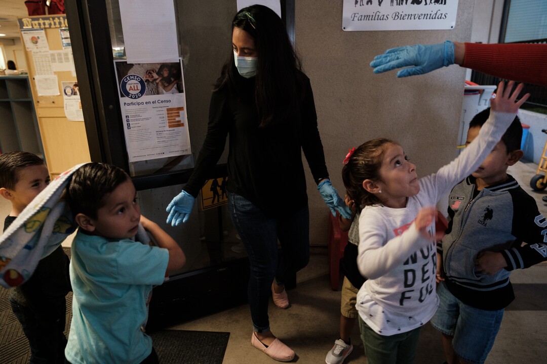 A caregiver wrangles children at a Head Start daycare center for the children of farmworkers in Stockton