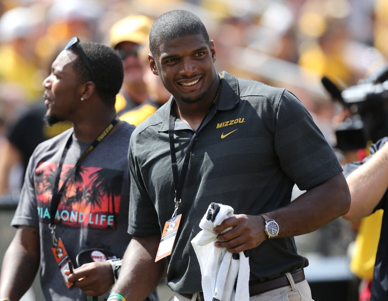 Michael Sam smiles while standing on the sideline of a game between Missouri, where he played in college, and South Dakota State on Saturday.