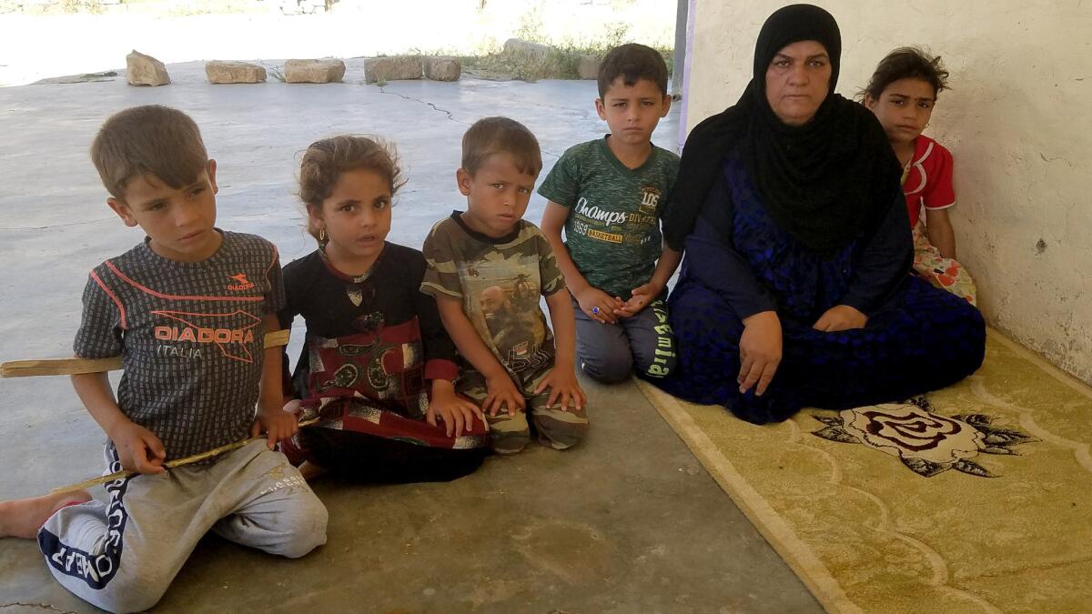 Khalida Yasin Hamid, 50, is flanked by grandchildren Yasin, 9, and Hameen, 6, whose father was killed in an airstrike in Khara’ib Jabar on Oct. 5. They share an abandoned home with relatives, including Bahaa Sager, 6, left, Sulav Hussein, 5, and Ali Sager, 5.