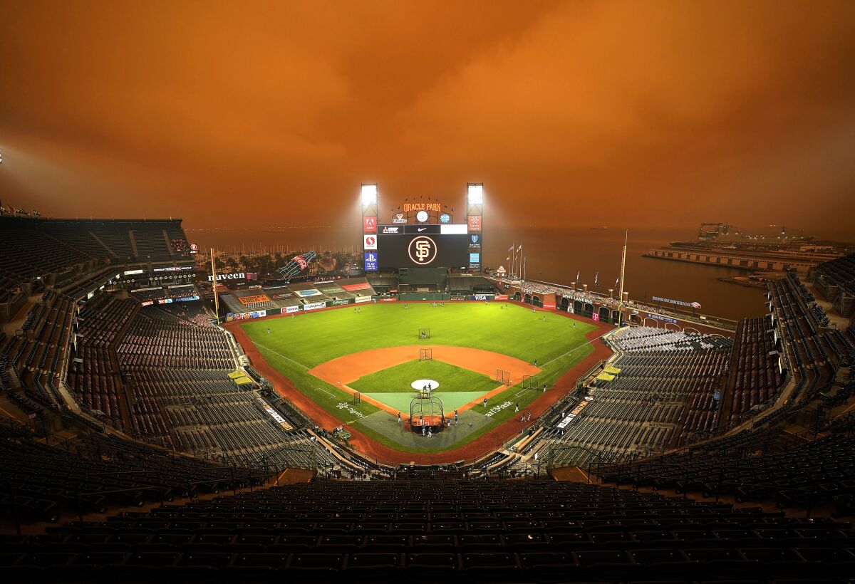 Smoke from wildfires obscures the sky over Oracle Park in San Francisco as the Seattle Mariners take batting practice before their baseball game against the San Francisco Giants on Sept. 9, 2020. (AP Photo/Tony Avelar)