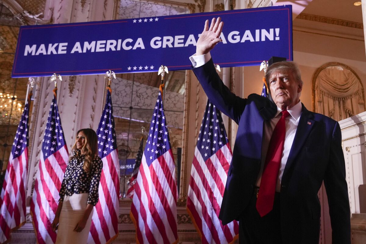 Former President Trump waves in front of a line of flags at Mar-a-Lago in Palm Beach, Fla.