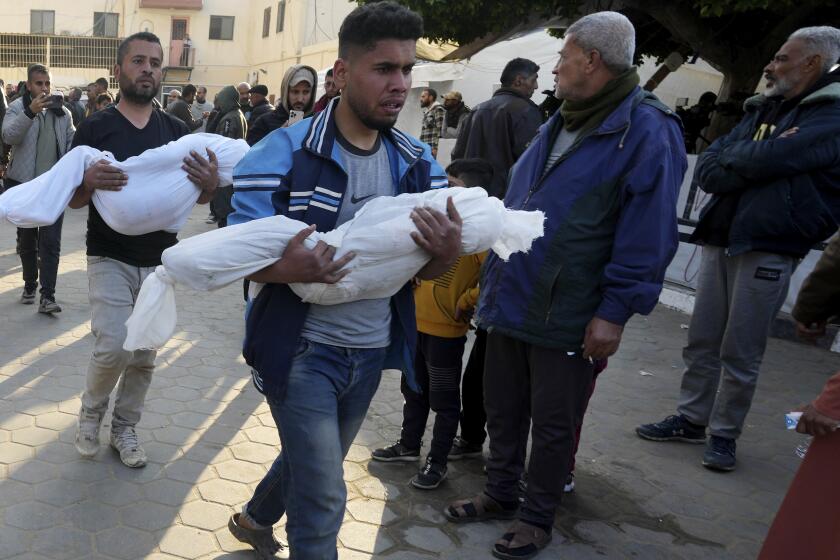 Palestinos llevan los cuerpos de niños asesinados en el bombardeo israelí de la Franja de Gaza al Hospital Al Aqsa en Deir al Balah el martes 20 de febrero de 2024. (AP Foto/Adel Hana)