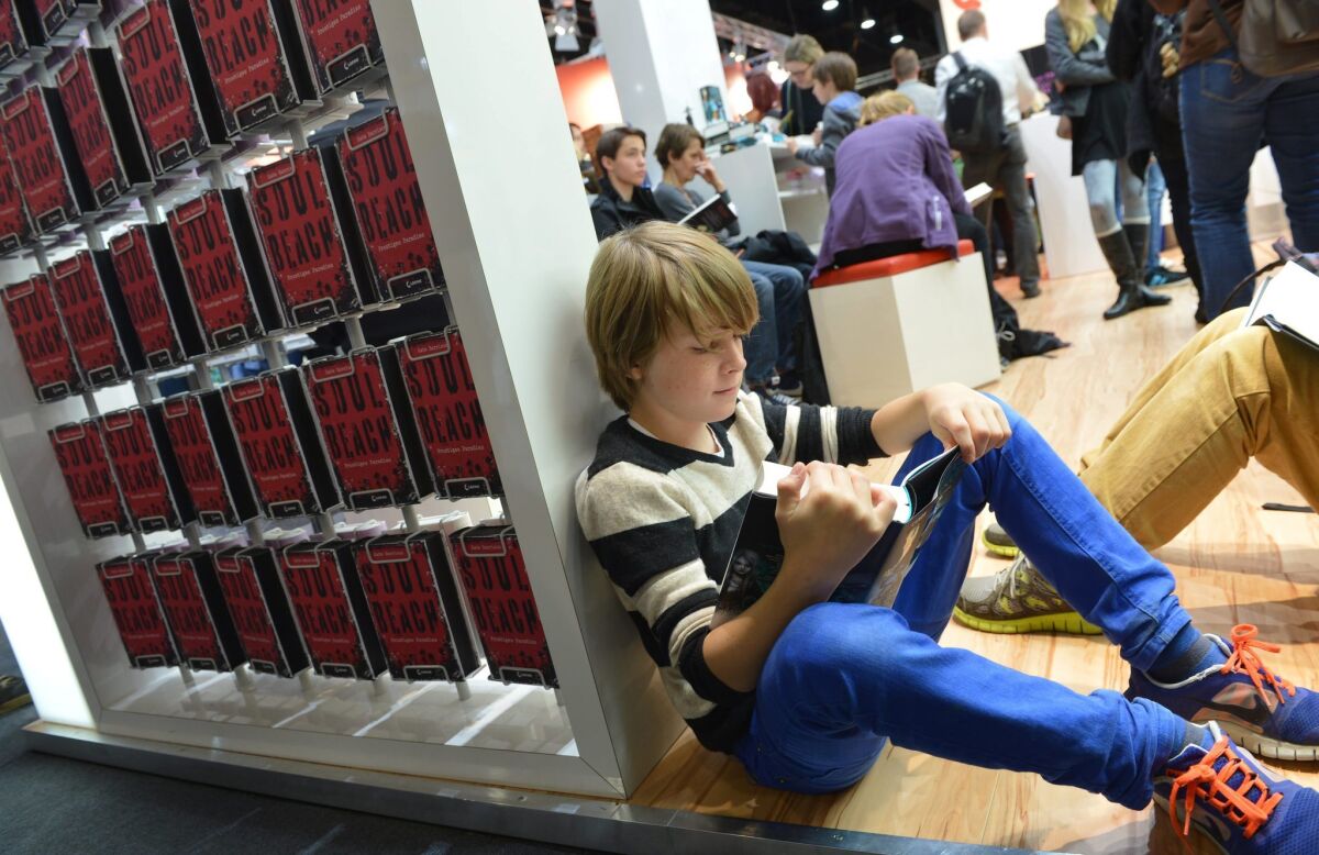 A young reader with a printed book at the Frankfurt Book Fair.