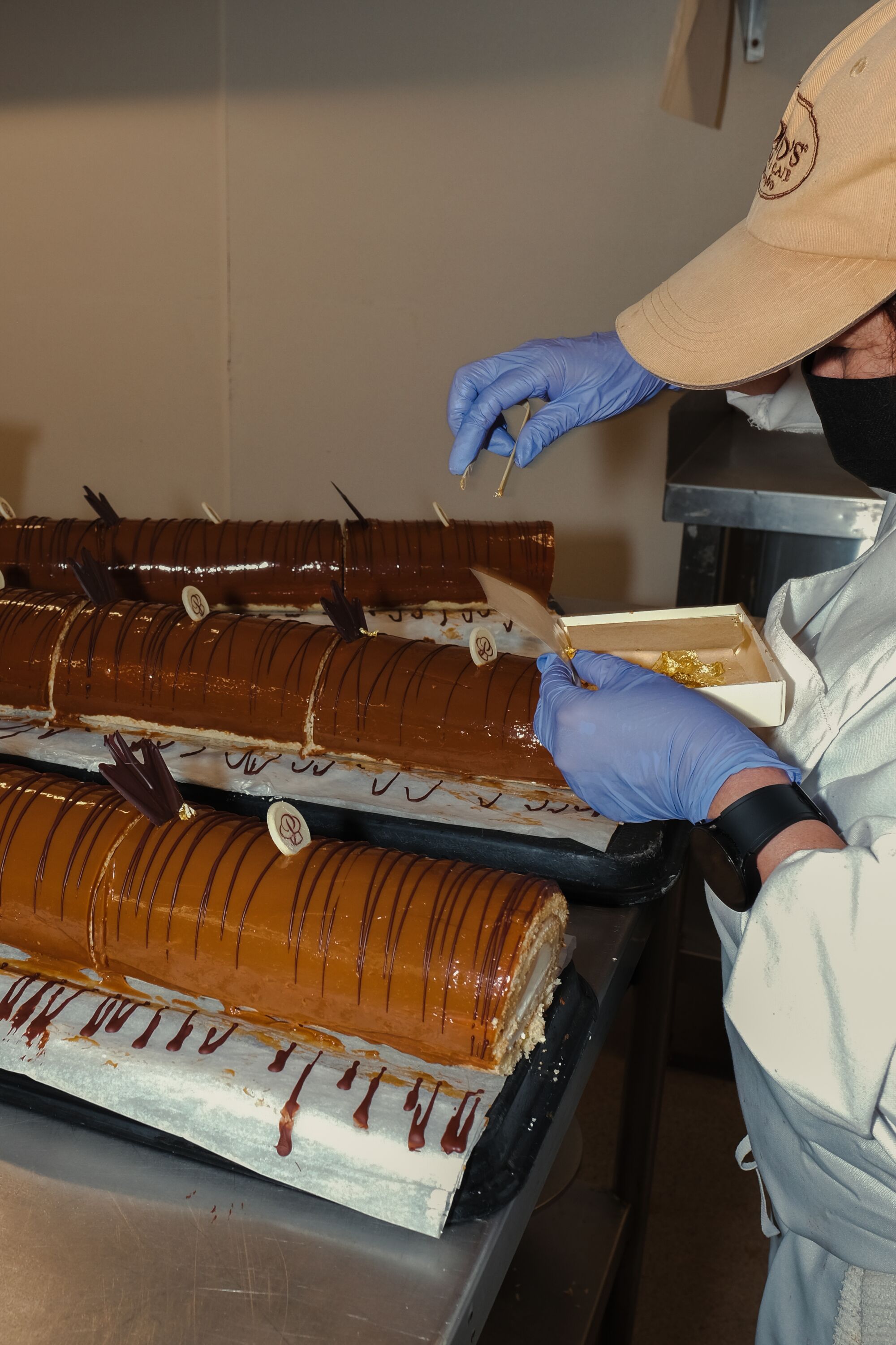 A baker decorates dulce de leche cake rolls at Porto’s Bakery in Glendale.