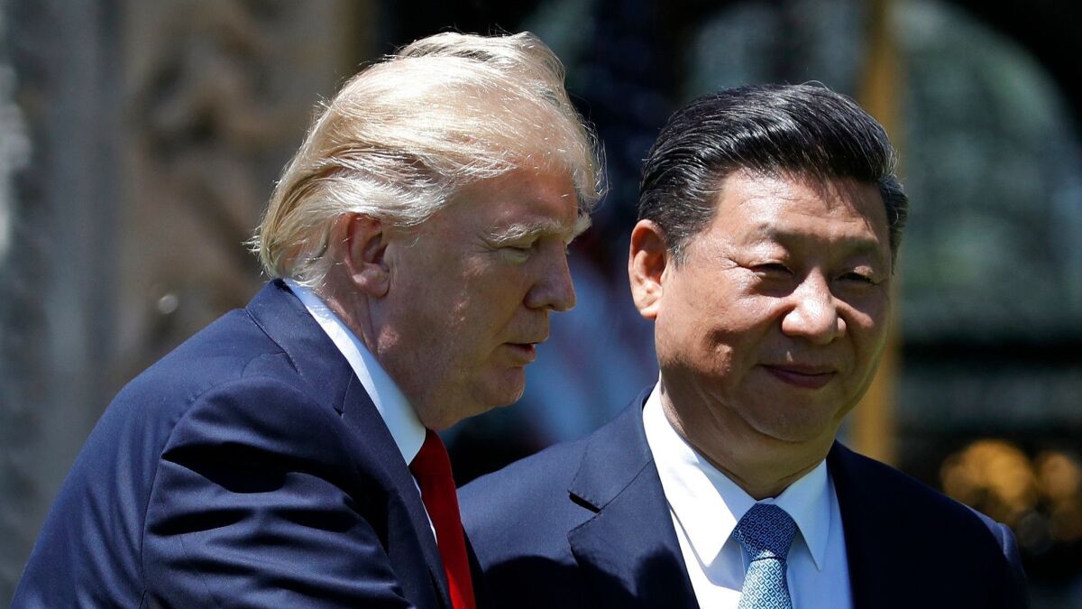 President Trump and Chinese President Xi Jinping walk together at Mar-a-Lago in Palm Beach, Fla.