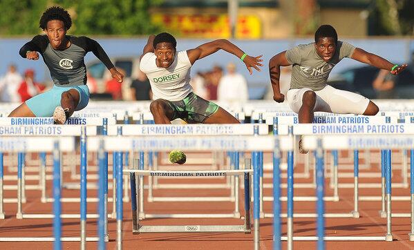 North Hollywood's Sike Azu Irondi, right, defeats Carson's Mackenzie Rickman, left, and Dorsey's Reggie Bell in the 110 hurdles at the City Section track and field championships at Birmingham High School Wednesday.