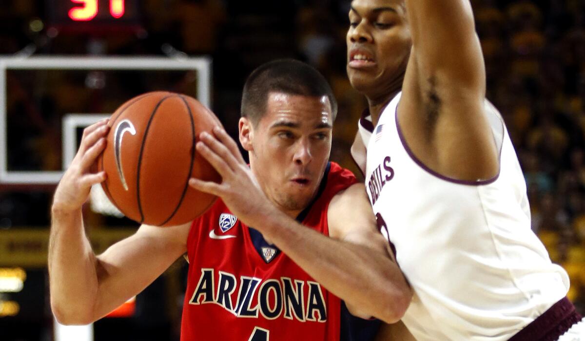 Arizona State guard Tra Holder tries to cut off a drive by Arizona guard T.J. McConnell in the first half Saturday afternoon.