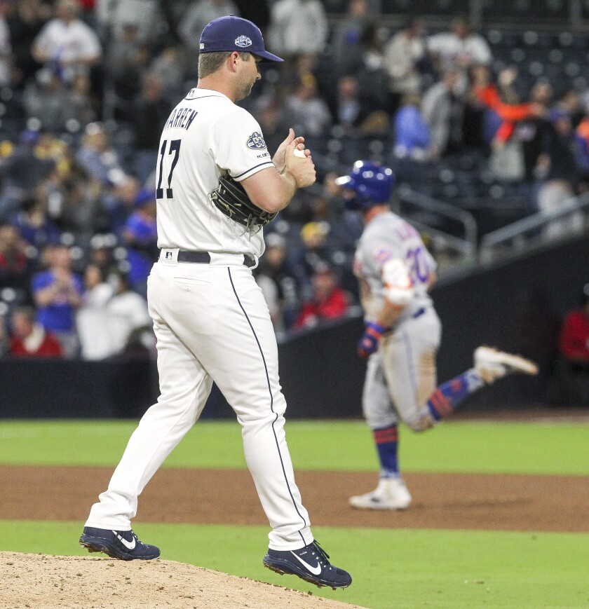 The Padres' Adam Warren walks off the mound as the Mets' Pete Alonso runs the bases after hitting a two-run home run in the ninth inning.