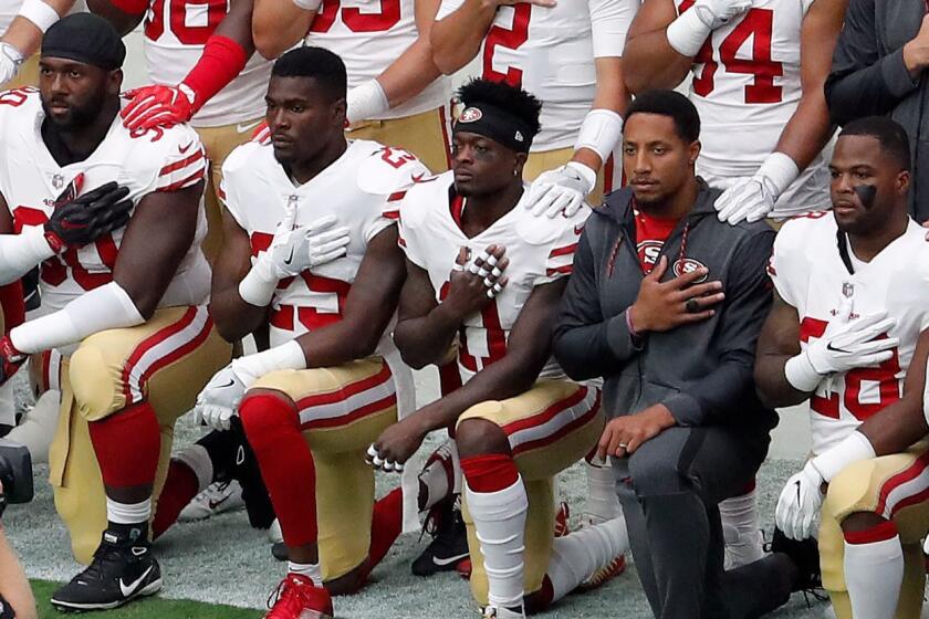 Members of the San Francisco 49ers kneel during the national anthem as others stand prior to an NFL football game against the Arizona Cardinals, Sunday, Oct. 1, 2017, in Glendale, Ariz. (AP Photo/Matt York)