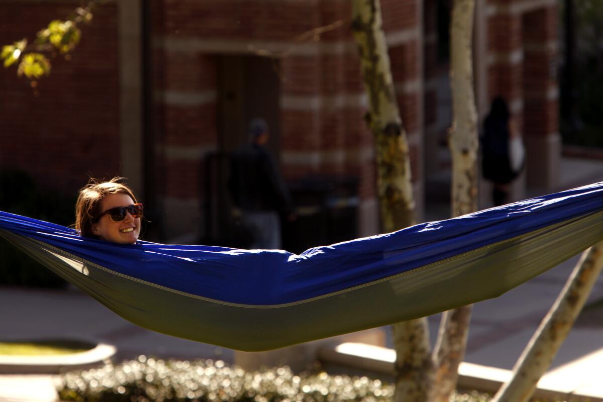 Katherine Landers, 21, reclines in a hammock while enjoying the warm day on the UCLA campus in Westwood on Friday.