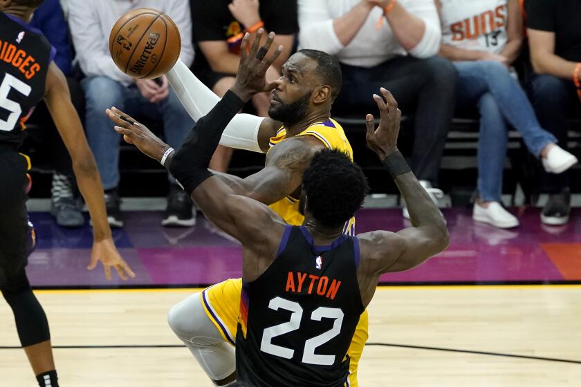 Los Angeles Lakers forward LeBron James (23) drives past Phoenix Suns center Deandre Ayton (22) during the first half of Game 5 of an NBA basketball first-round playoff series, Tuesday, June 1, 2021, in Phoenix. (AP Photo/Matt York)