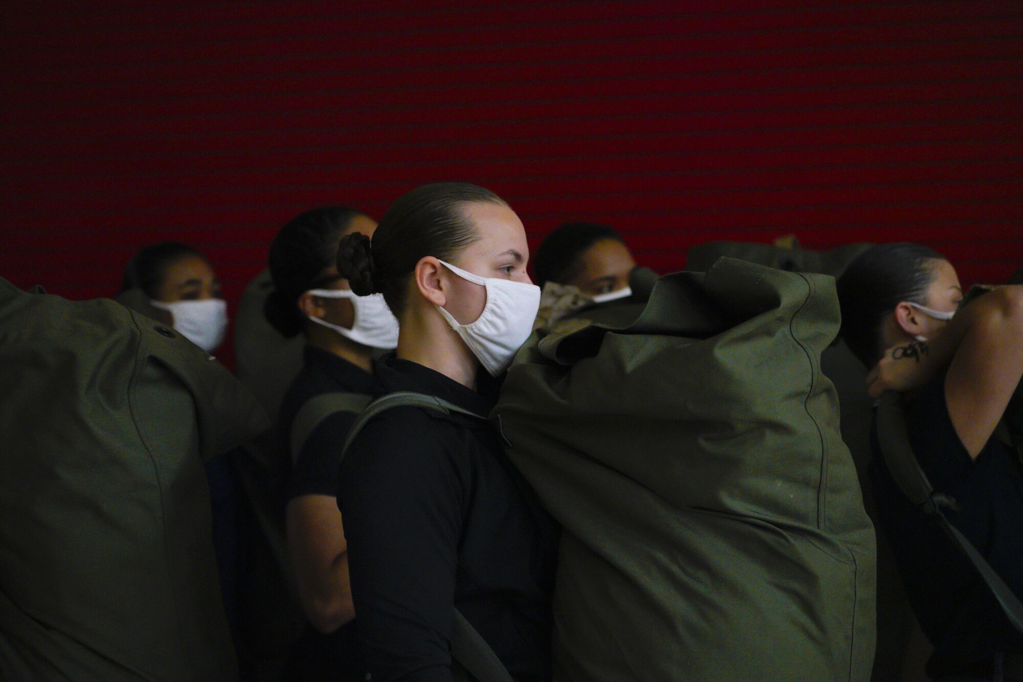 Recruits carry their seabags and await their next orders during their processing for their first day of boot camp.