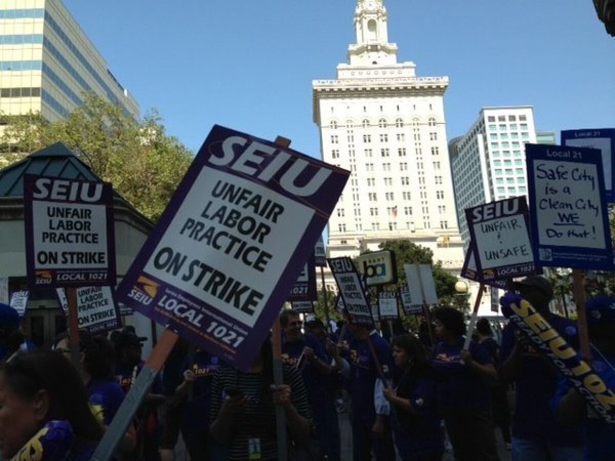 Union workers protest in front of Oakland City Hall.