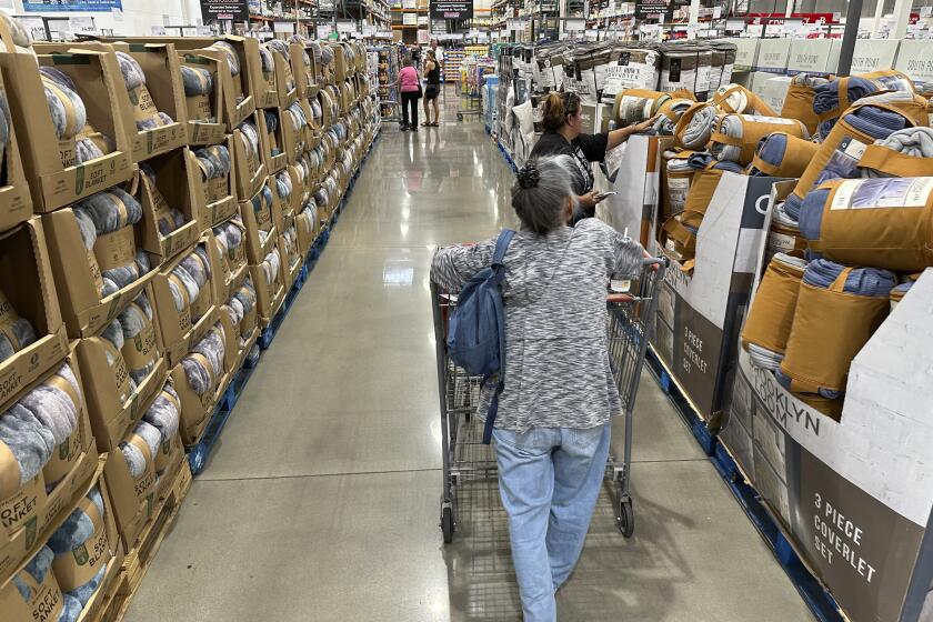 File - Shoppers look over blankets on sale in a Costco warehouse on Aug. 24, 2023, in Sheridan, Colo. On Thursday, the Commerce Department issues its first of three estimates of how the U.S. economy performed in the third quarter of 2023. (AP Photo/David Zalubowski, File)