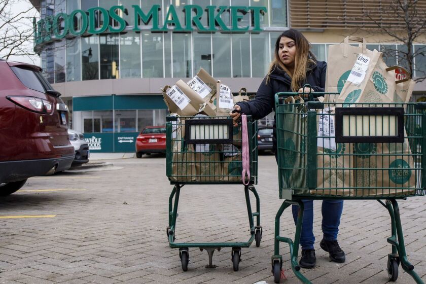 Alid Alvarado transports orders for three different Instacart customers to her car at Whole Foods. (Brian Cassella/Chicago Tribune/TNS) ** OUTS - ELSENT, FPG, TCN - OUTS **