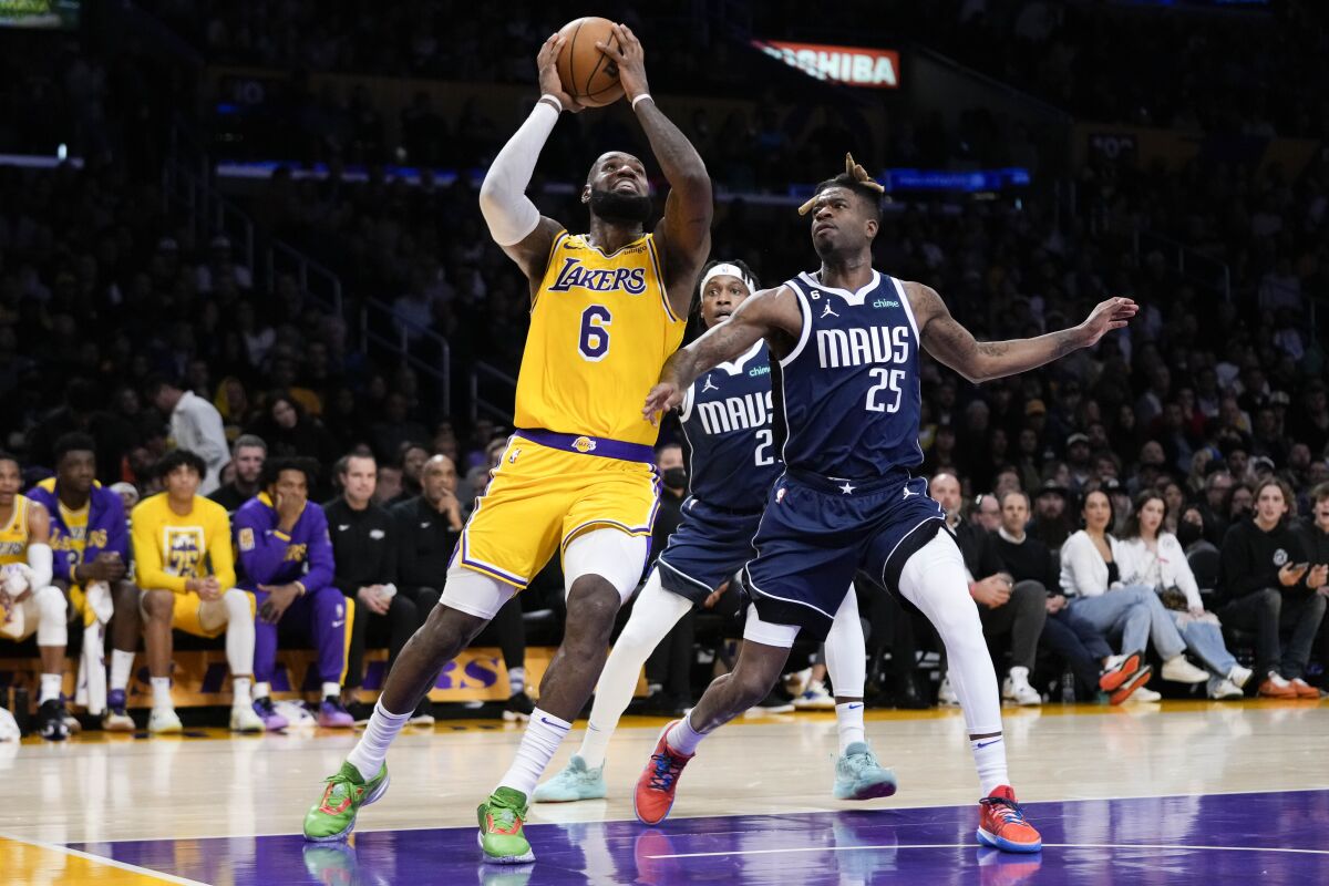 LeBron James drives to the basket past Dallas' Reggie Bullock.