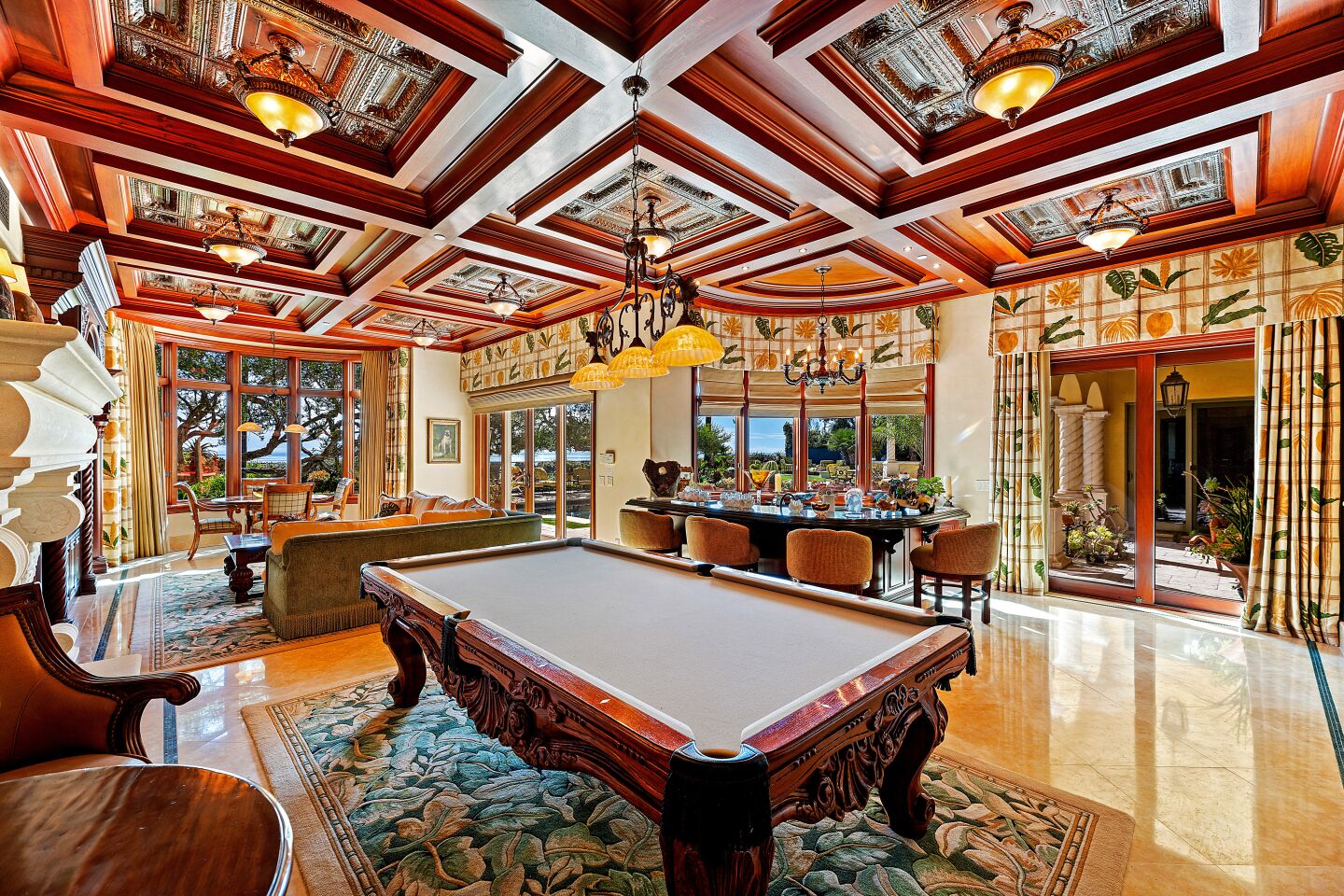 Billiards table, dark wood coffered ceiling, marble floors and a curved bar in the billiards room.