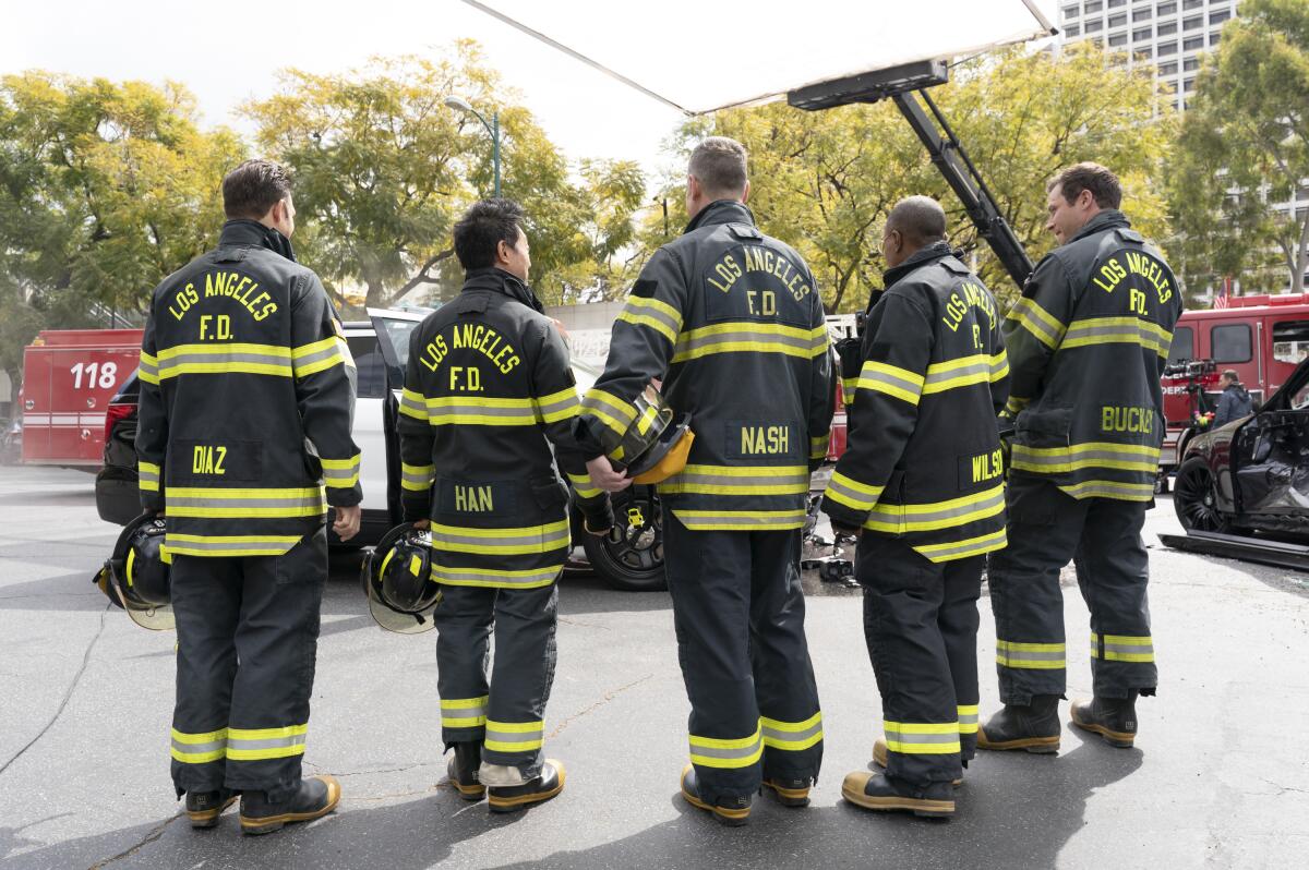 Five firefighters standing in a row in a scene from the TV series '9-1-1'