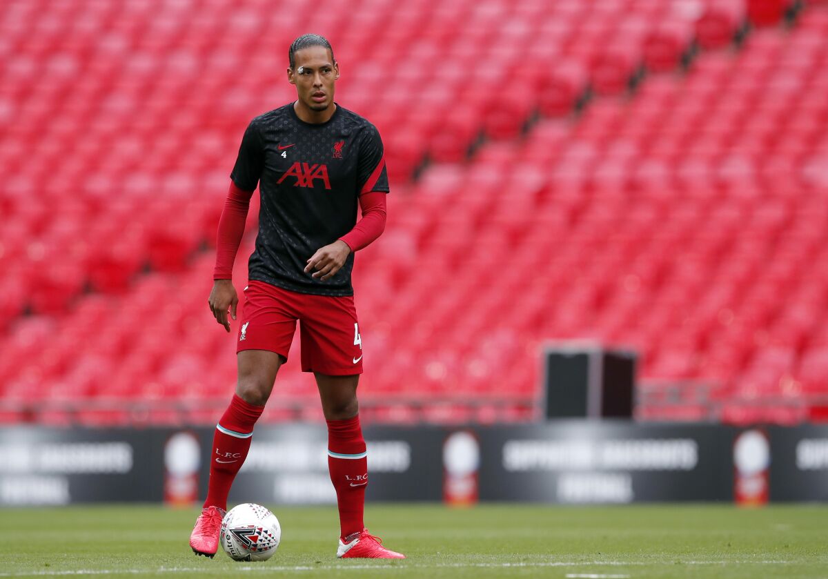 Liverpool's Virgil van Dijk warms up before their English FA Community Shield soccer match against Arsenal at Wembley stadium in London, Saturday, Aug. 29, 2020. Liverpool center-back Virgil van Dijk says he is “ready to crack on” with more minutes in the club’s next pre-season match as he returns from knee surgery. It's still unclear though if he’ll be ready for the start of the new season. Norwich visits Anfield for the Aug. 14 season opener but Van Dijk says he’s just focused on increasing his workload Thursday, Aug. 5 2021 in a friendly against Bologna at the Premier League team’s training camp in Evian, France. (Andrew Couldridge/Pool via AP, file)