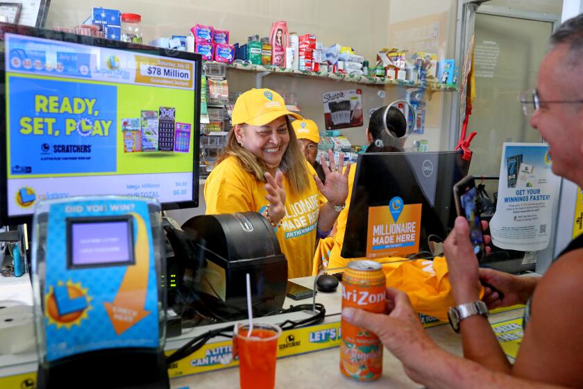 LOS ANGELES, CA - JULY 20: Maria Menjivar, owner, gives away a free t-shirt where a $1-billion Powerball ticket was sold at her store Las Palmitas Mini Market in downtown on Thursday, July 20, 2023 in Los Angeles, CA. The winner, who remains unidentified, purchased their ticket at Las Palmitas Mini Market at East 12th Street and Wall Street. (Gary Coronado / Los Angeles Times)