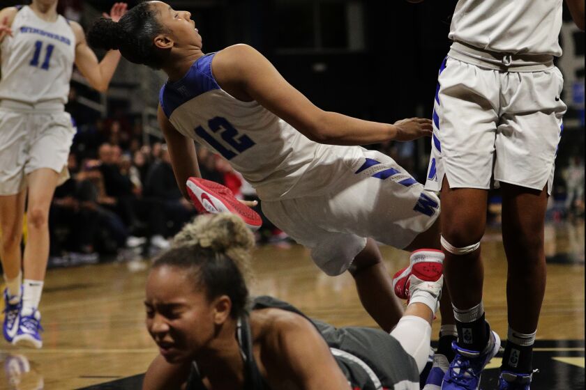 LONG BEACH, CA - FEBRUARY 28, 2020: Mater Dei Caia Elisaldez (11) lands hard on the court after being fouled by Windward Juju Watkins (12) in the Southern Section Open Division Final at the Pyramid on February 28, 2020 in Long Beach, California.(Gina Ferazzi/Los AngelesTimes)