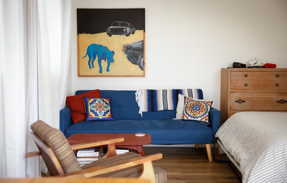 A chair, blue coach, dresser and bed make up the living space in an ADU.