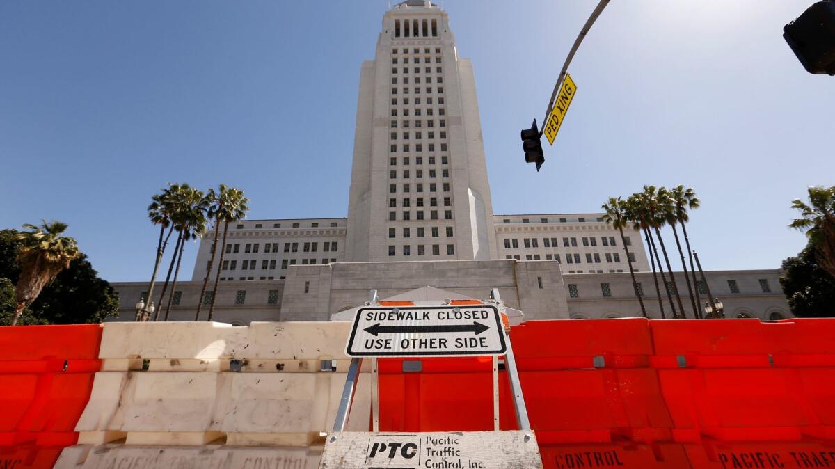 The sidewalk in front of City Hall is barricaded for a film production.