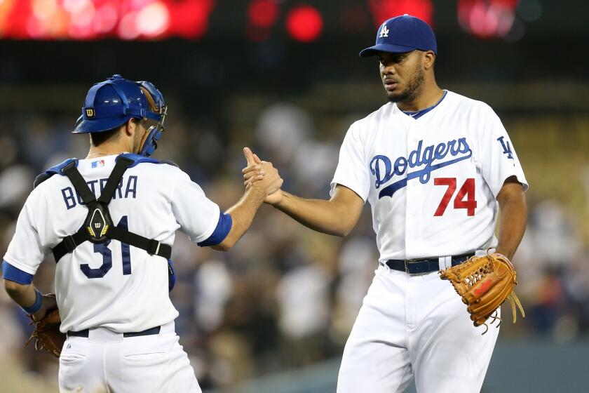 Drew Butera, left, and Kenley Jansen, right, celebrate the Dodgers' 6-3 win Tuesday over the Reds at Dodger Stadium.