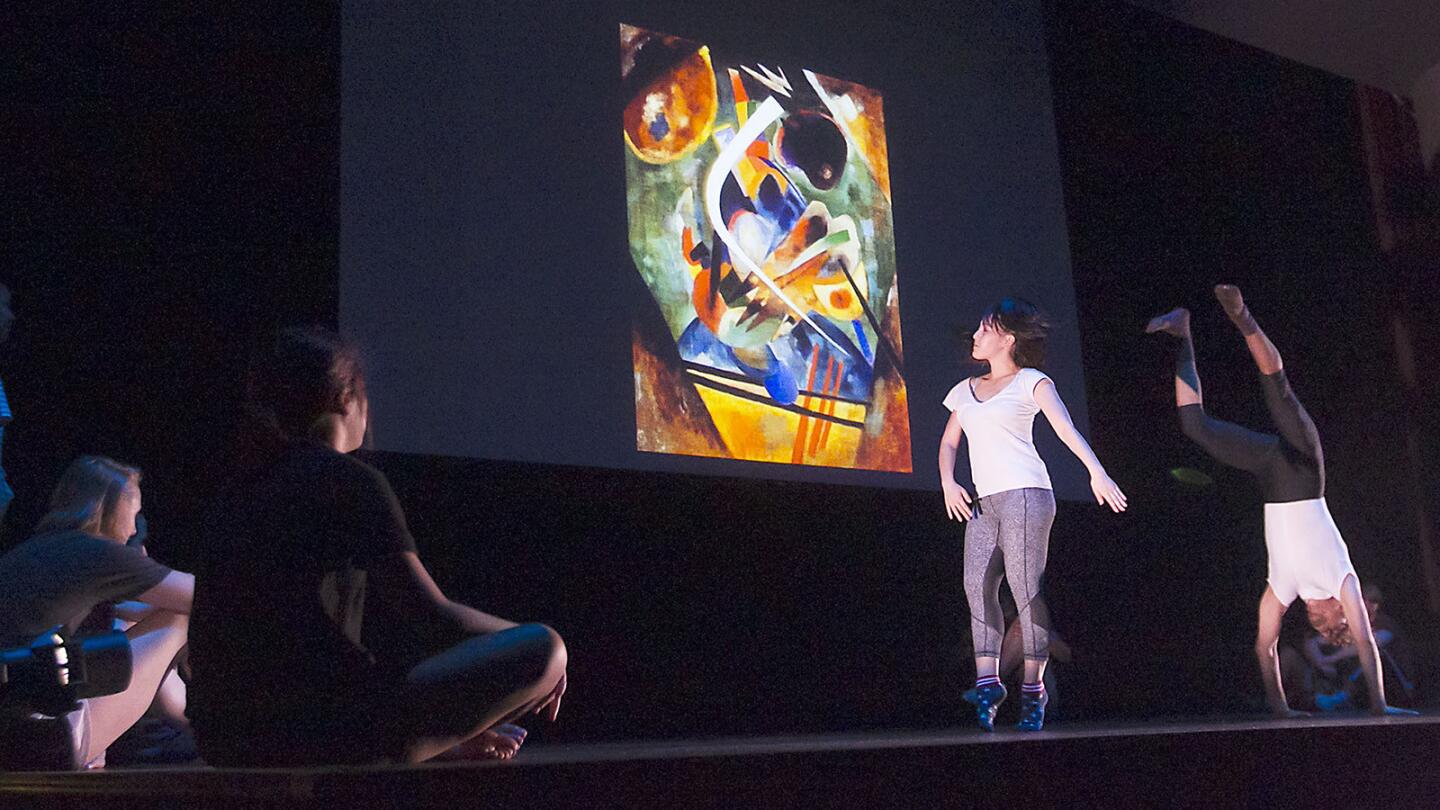 Students from Orange Coast College use a historical painting projected behind them to inspire improv dance movement during a performance in the Robert Moore Theater on Tuesday.