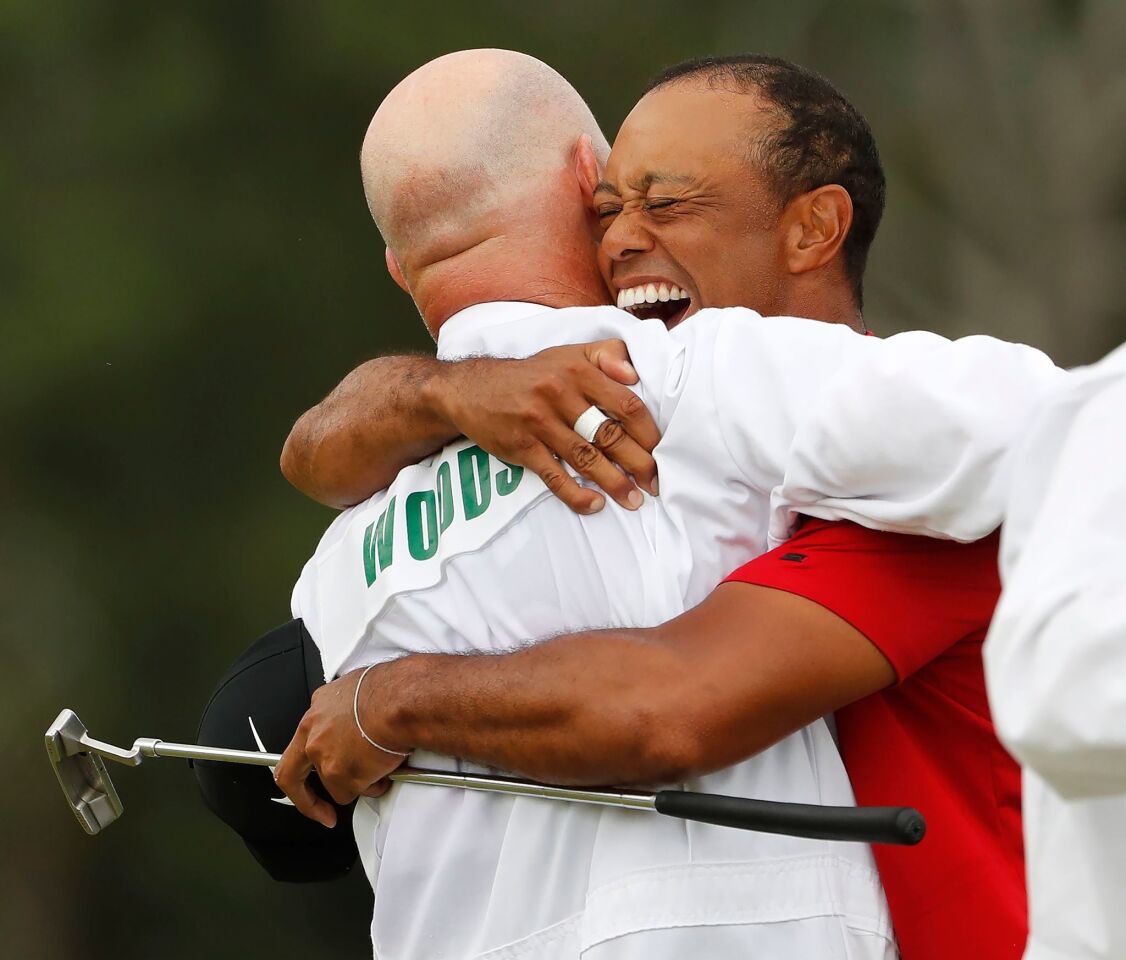Tiger Woods celebrates with caddie Joe LaCava after winning the 2019 Masters Tournament on Sunday at the Augusta National Golf Club in Augusta, Ga.
