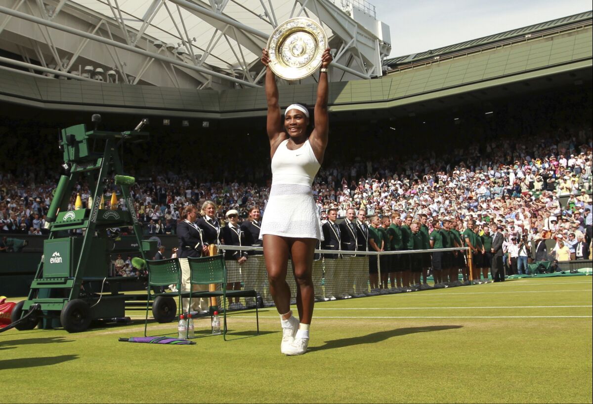 FILE - Serena Williams of the United States holds up the trophy after winning the women's singles final against Garbine Muguruza of Spain at the All England Lawn Tennis Championships in Wimbledon, London, Saturday, July 11, 2015. Chris Evert appreciates that she, Serena Williams and other Wimbledon women's singles champions will now be listed on the All England Club's honor boards in a Centre Court hallway simply by their first initial and last name — the way the men's title winners always have been — instead of preceded by “Miss” or “Mrs.”(Sean Dempsey/Pool via AP, File)
