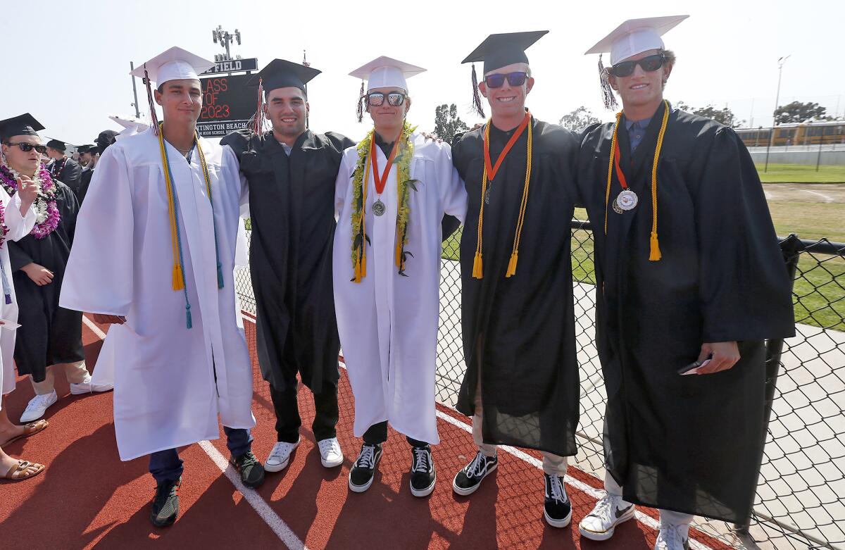 Seniors from the baseball team gather before walking into the Huntington Beach High graduation ceremony on Tuesday.