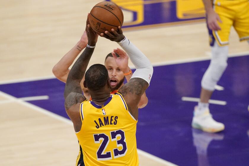 The Lakers' LeBron James shoots over the Warriors' Stephen Curry for the winning three-pointer May 19, 2021.