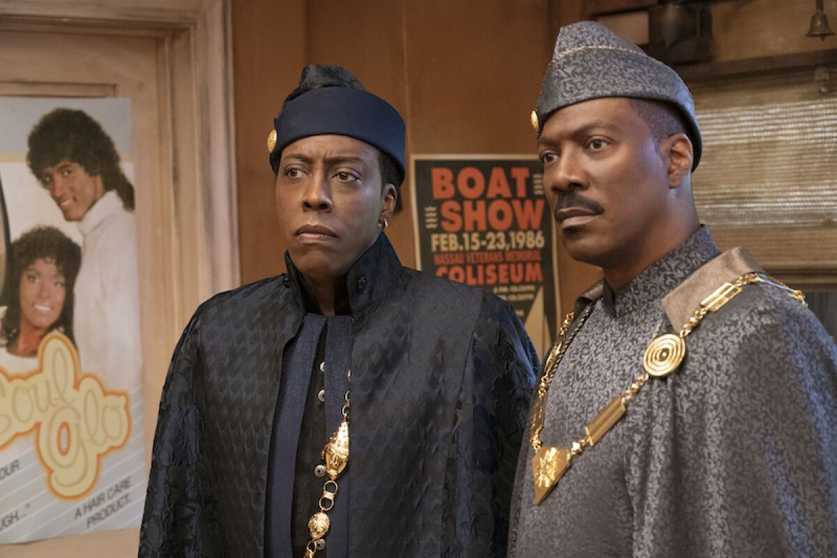 Arsenio Hall and Eddie Murphy standing side-by-side in "Coming 2 America."