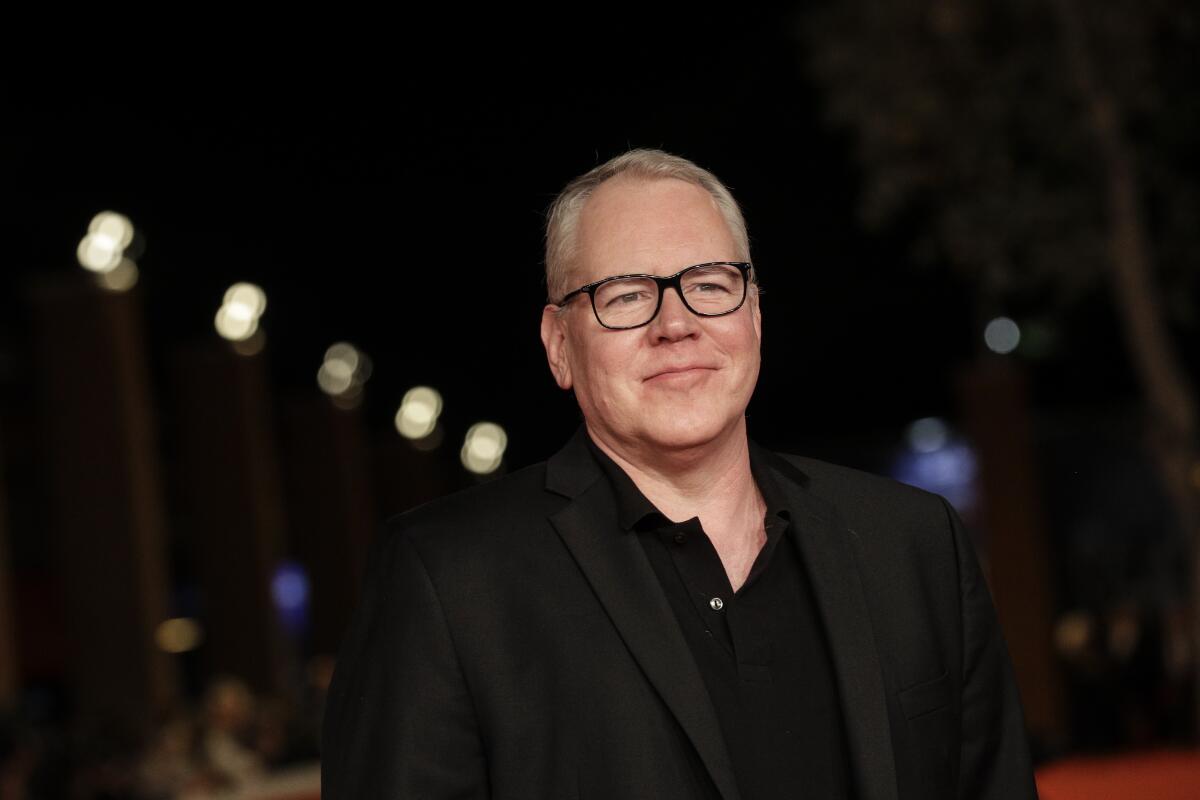 Bret Easton Ellis in a black outfit poses on the red carpet