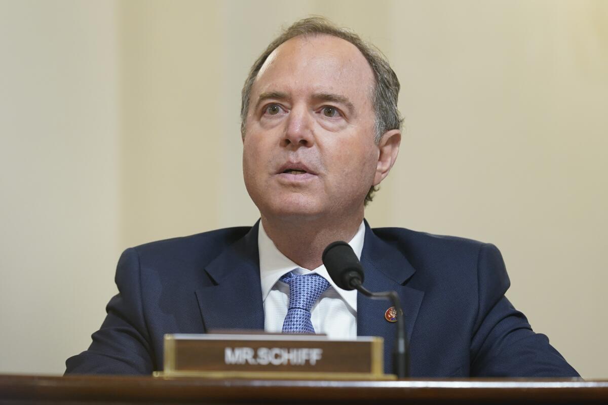 Rep. Adam Schiff sits at a microphone with his name plate in front