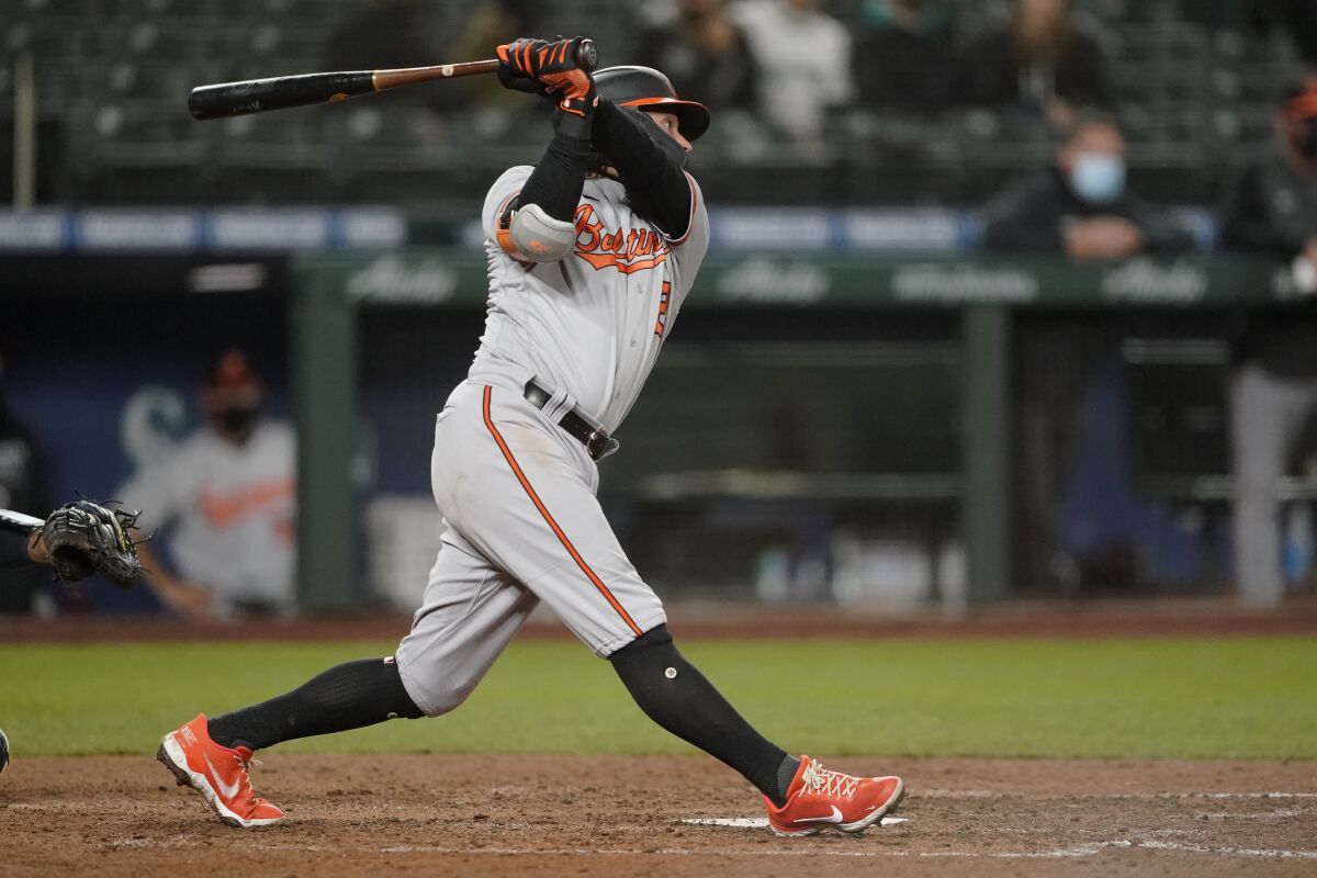 Baltimore Orioles' Freddy Galvis follows through on a two-run home run during the eigth inning of a baseball game against the Seattle Mariners, Monday, May 3, 2021, in Seattle. (AP Photo/Ted S. Warren)