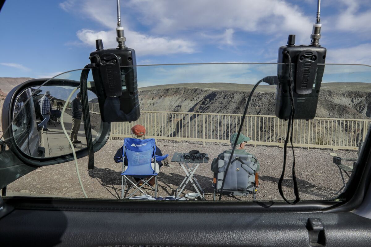 DEATH VALLEY, CA, MARCH 18, 2019 --- Candace, 68, and Richard Campbell, 71, of Pacific Cove, look for military aircrafts with their eyes peeled to sky and ears focused on flight chatter coming from two scanners hanging from camper door. Campbells, parked at Father Father Crowley look out point on I-90, have been making the eight hour trek, in there 2001 Dodge 2500 cargo van that was converted to a camper, to Rainbow Canyon to watch fighter jets blast through the gorge. (Irfan Khan / Los Angeles Times)