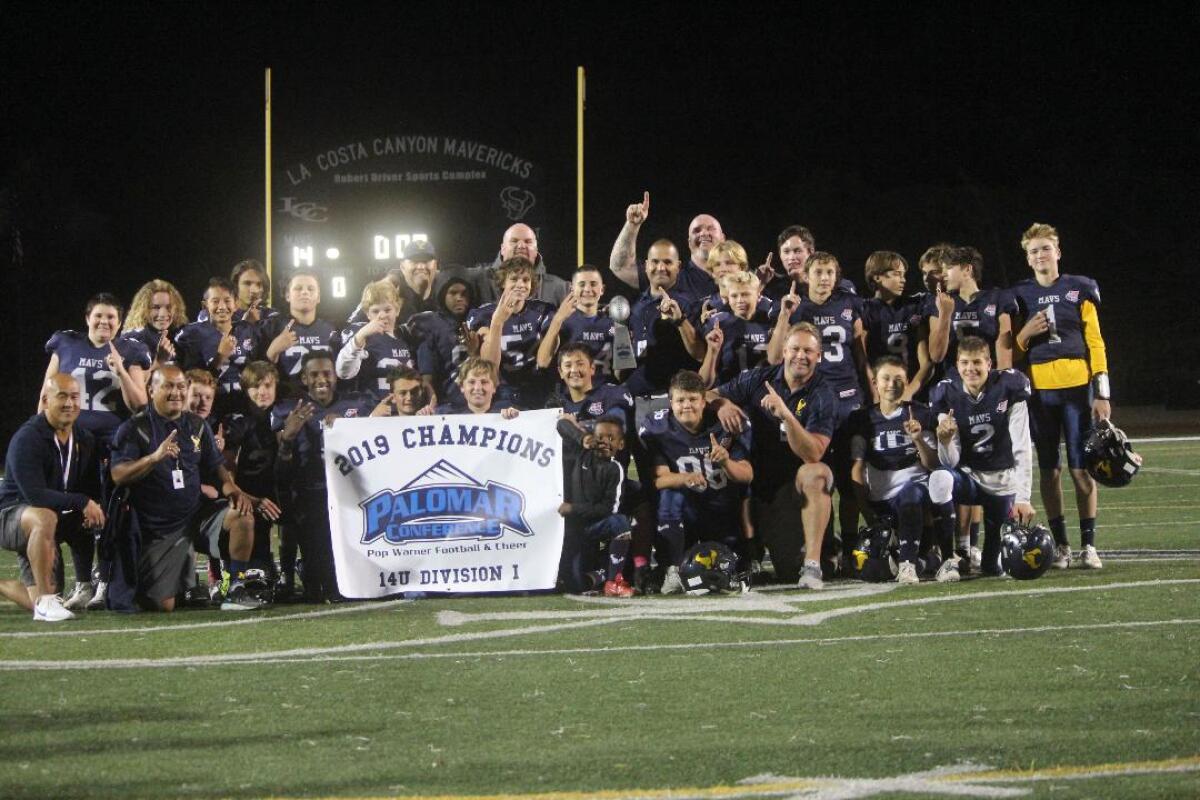 The La Costa Canyon Mavericks Division 1 14U team and coaching staff holding up the 2019 Palomar Conference Pop Warner Football Champions banner and displaying their game rings.