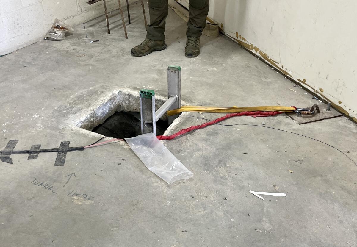 A square in a concrete floor with a ladder poking out 