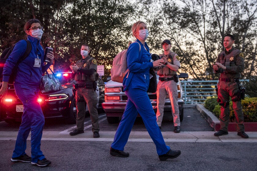 Orange County sheriff's deputies applaud as nurses from the cardiac rehab unit walk to their cars after a shift at Mission Hospital in Mission Viejo this month.