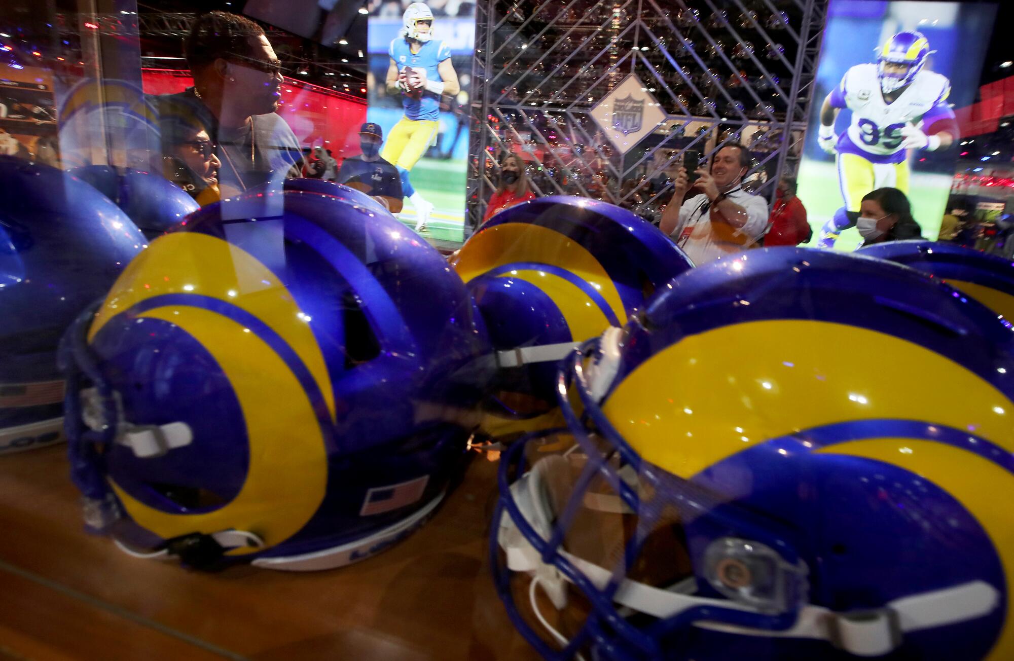 Fans take pictures at a display featuring the Los Angeles Rams and the Los Angeles Chargers.
