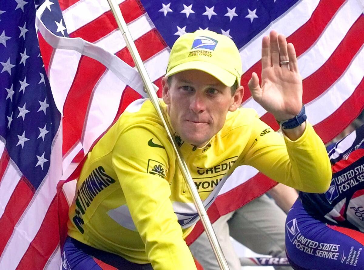 Lance Armstrong riding down the Champs Elysees with an American flag after the 21st and final stage of the Tour De France in 2000.