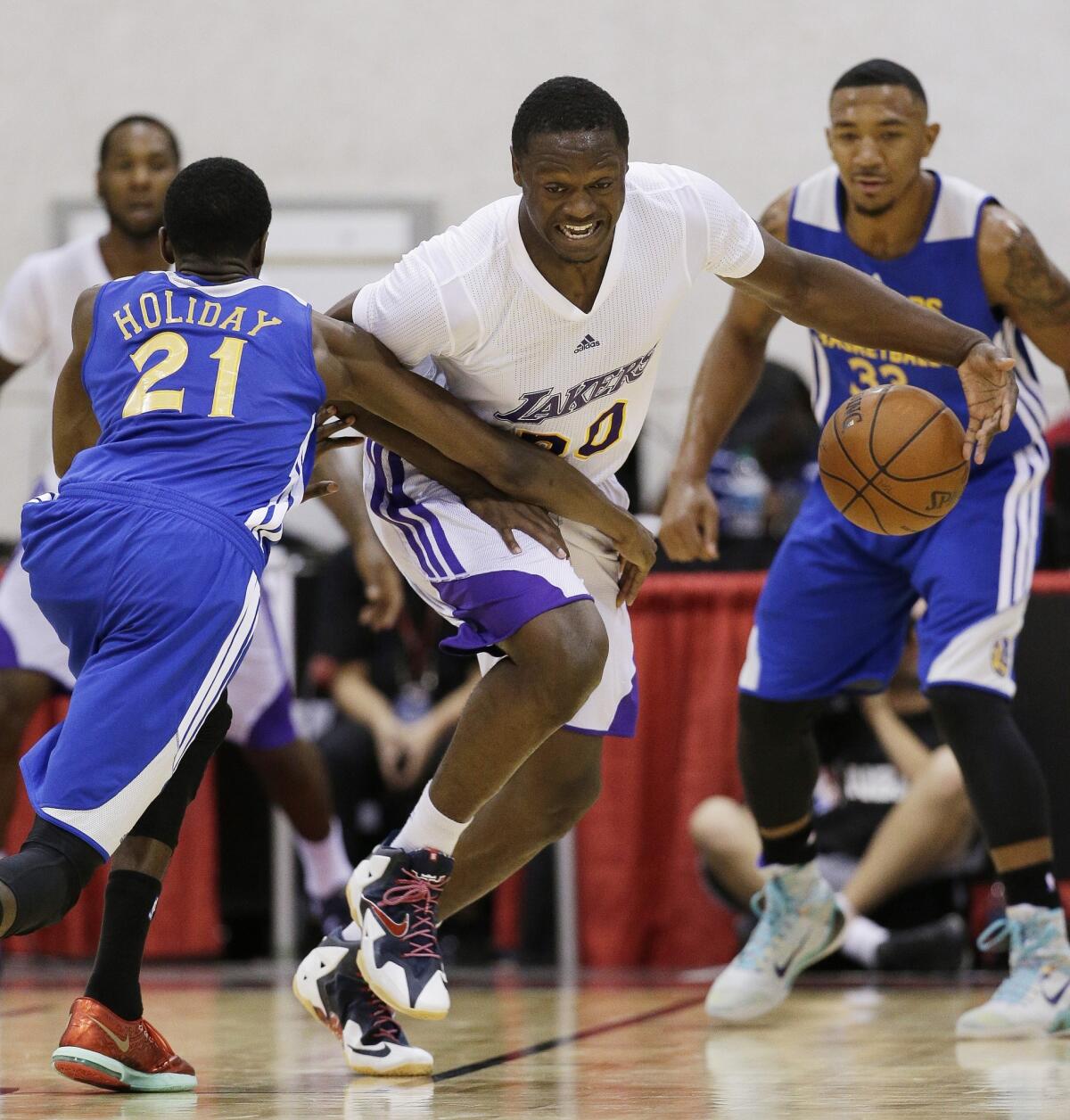 Julius Randle drives up the court against the Golden State Warriors' Justin Holiday during a July 14 NBA summer league game in Las Vegas.