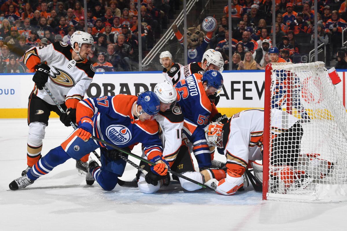 Ducks goaltender Lukas Dostal covers up the puck as players battle in front of the net.